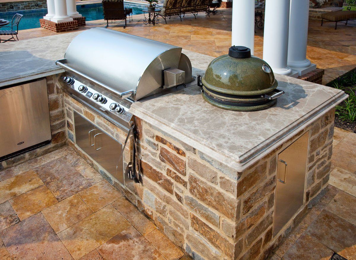 A grill is sitting on top of a brick counter.
