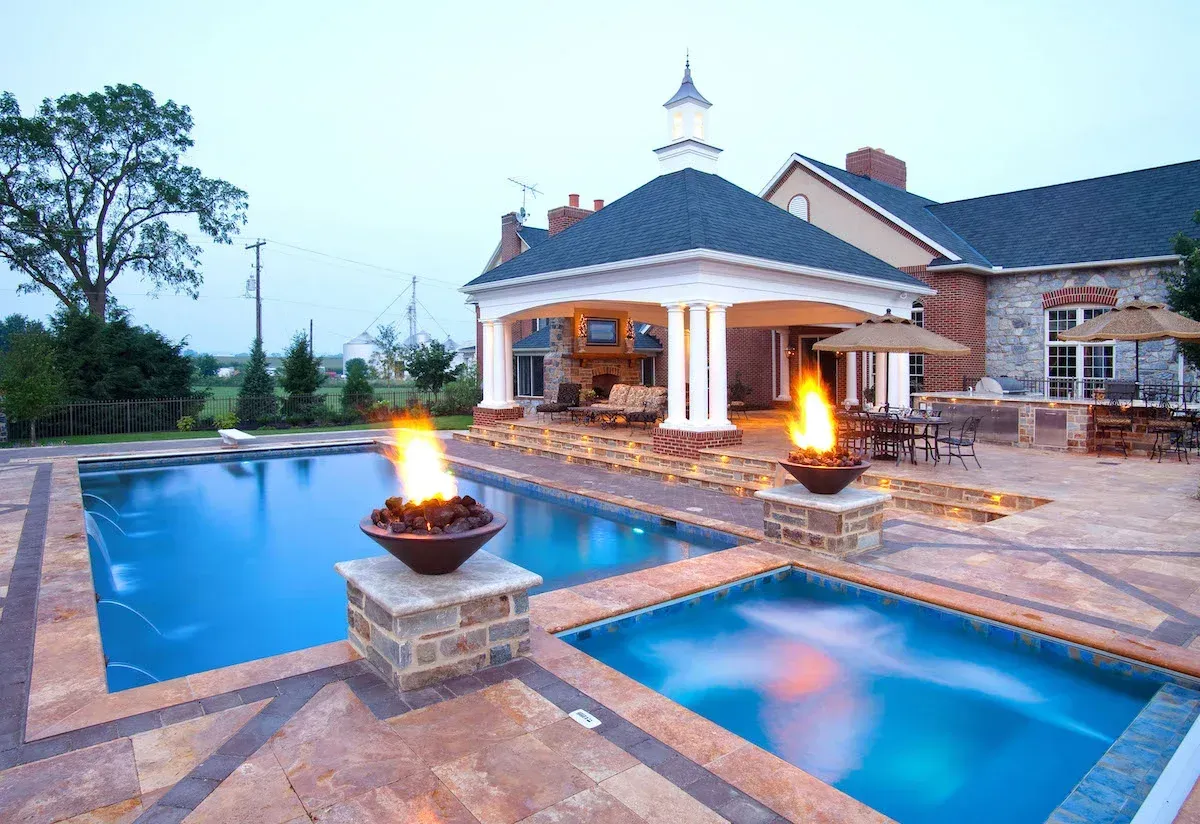 A large swimming pool with a fire pit in the middle