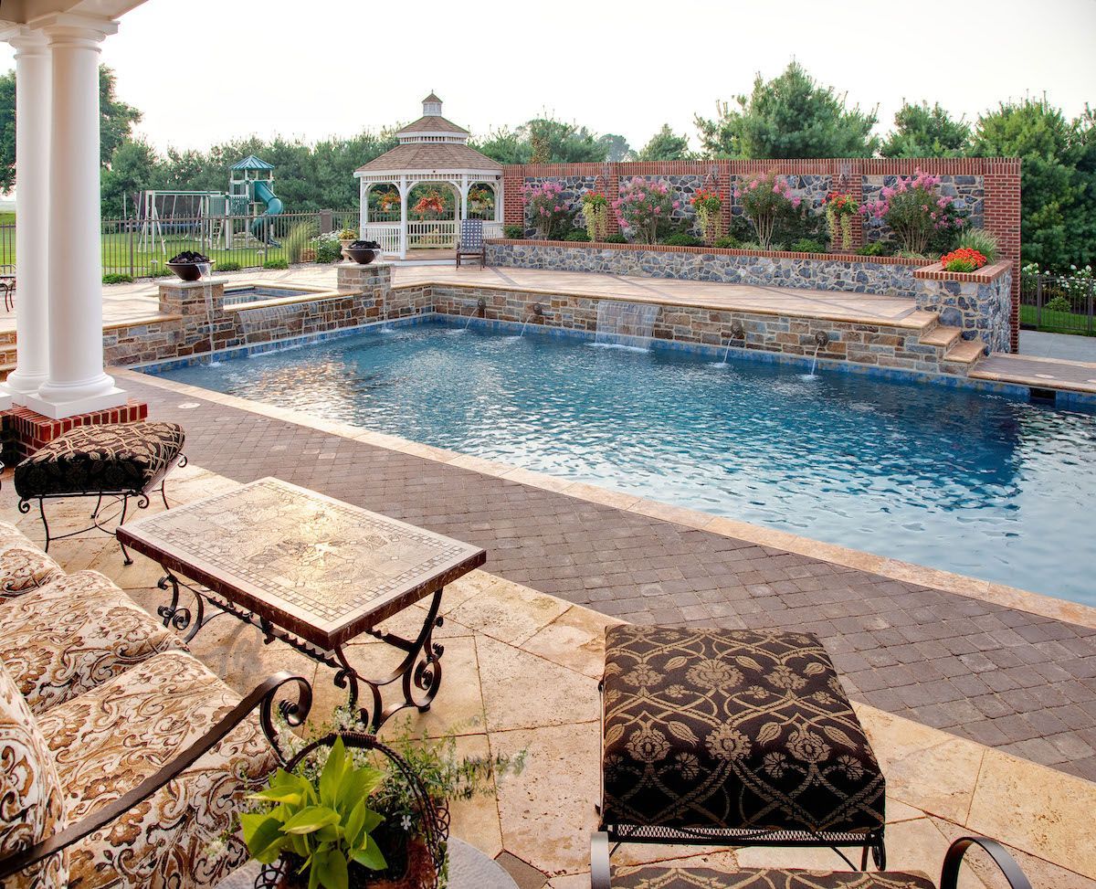 A large swimming pool with a gazebo in the background