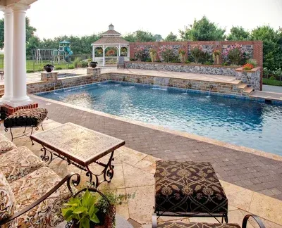 A large swimming pool with a gazebo in the background