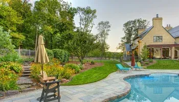 A large house with a swimming pool in front of it.