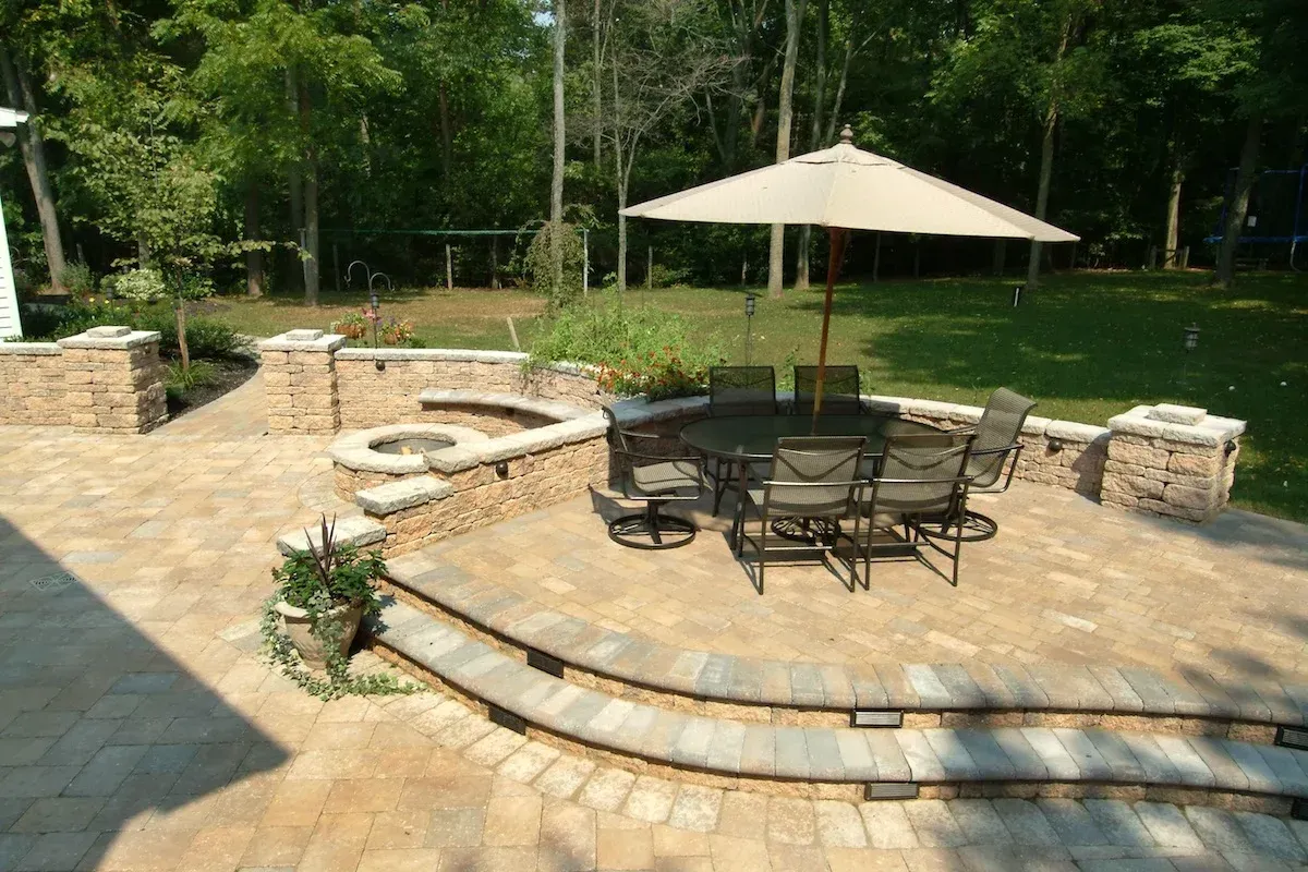 A patio with a table and chairs and an umbrella.