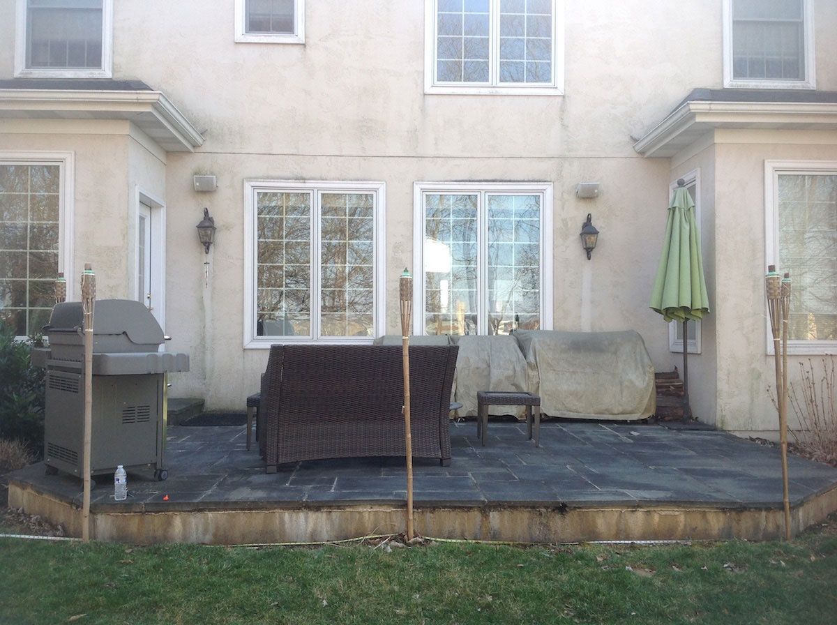 The backyard of a house with a patio and a grill