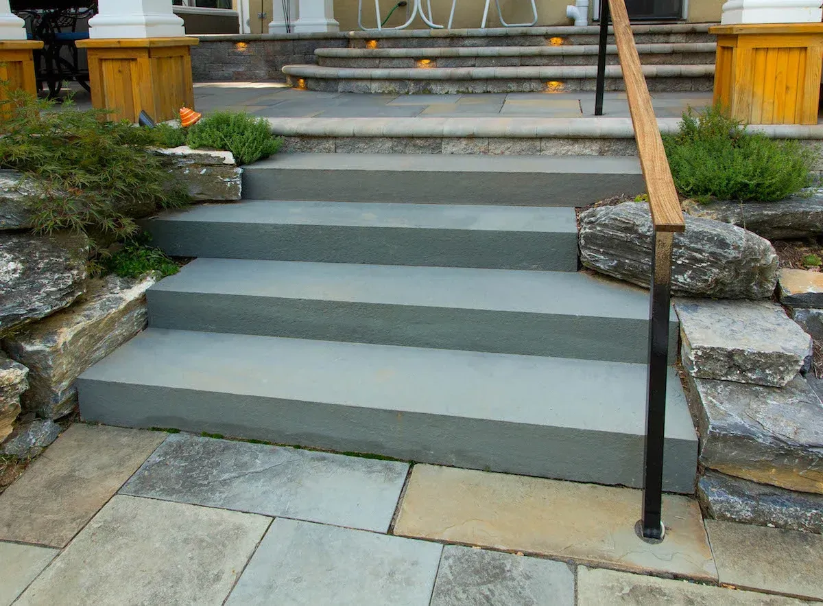 A set of stairs leading up to a house with a wooden railing