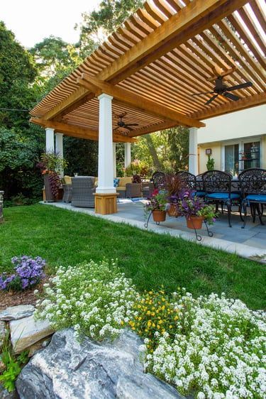 There is a pergola in the backyard with a ceiling fan.