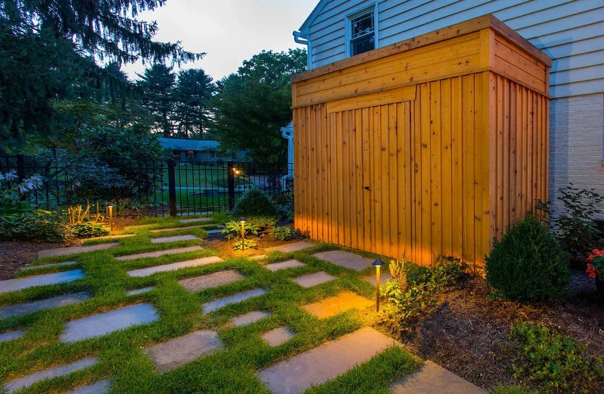 There is a wooden shed in the backyard of a house.