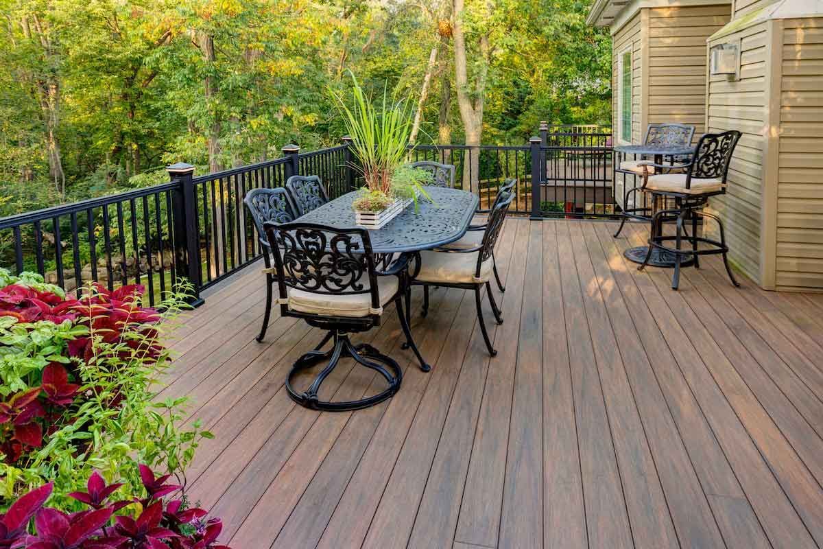 A wooden deck with a table and chairs on it.
