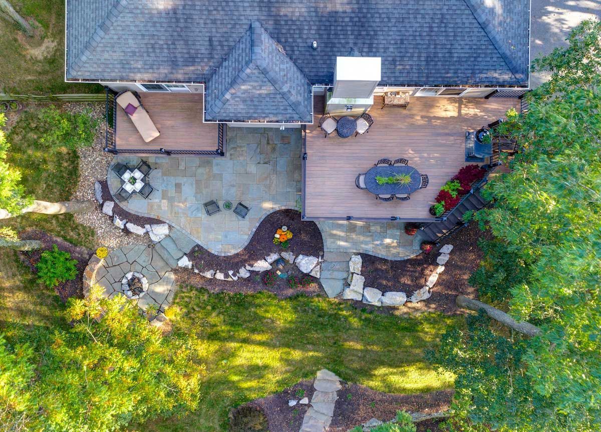 An aerial view of a house with a large patio surrounded by trees.