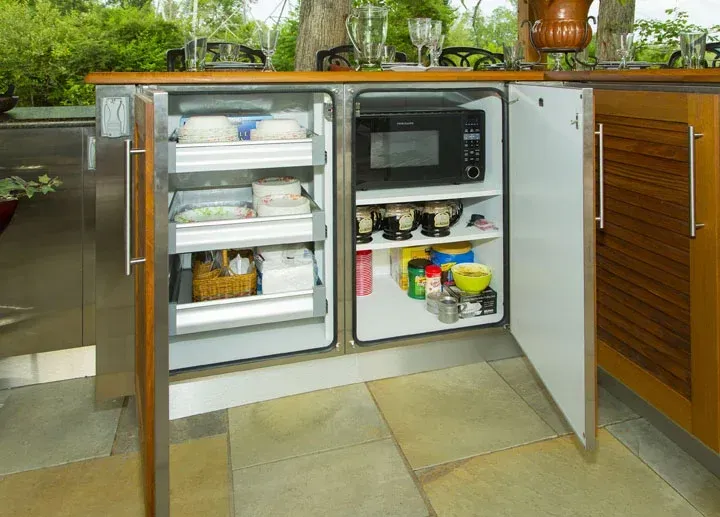 A kitchen with a refrigerator and a microwave in it