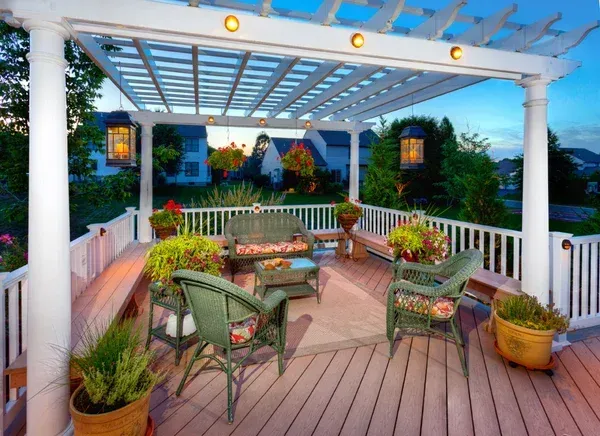 A deck with a pergola and furniture on it