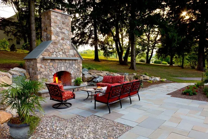 A patio with a fireplace and a couch and chairs