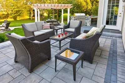 A patio with wicker furniture and a table with candles on it.