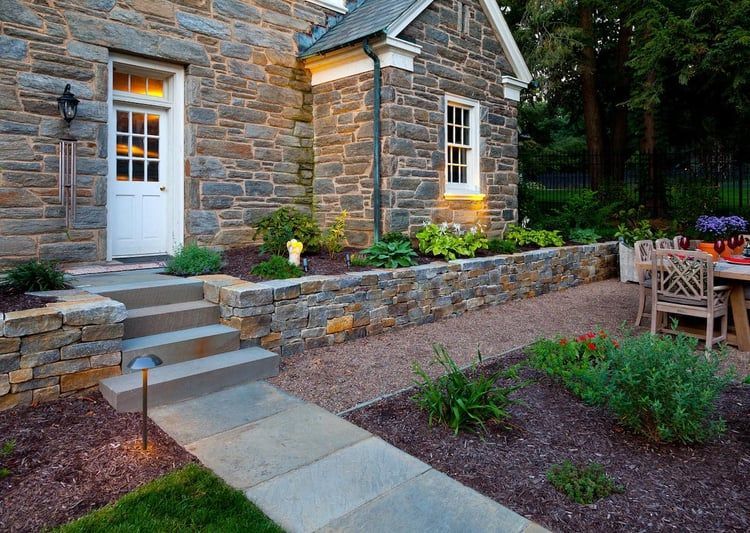 A stone house with a stone walkway leading to the front door.