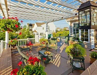 A large deck with a pergola and flowers on it