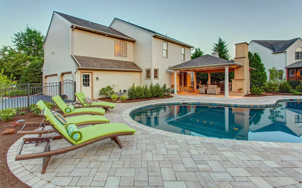 A large house with a large swimming pool in front of it.