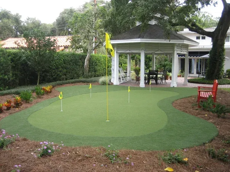 A putting green with a gazebo in the background
