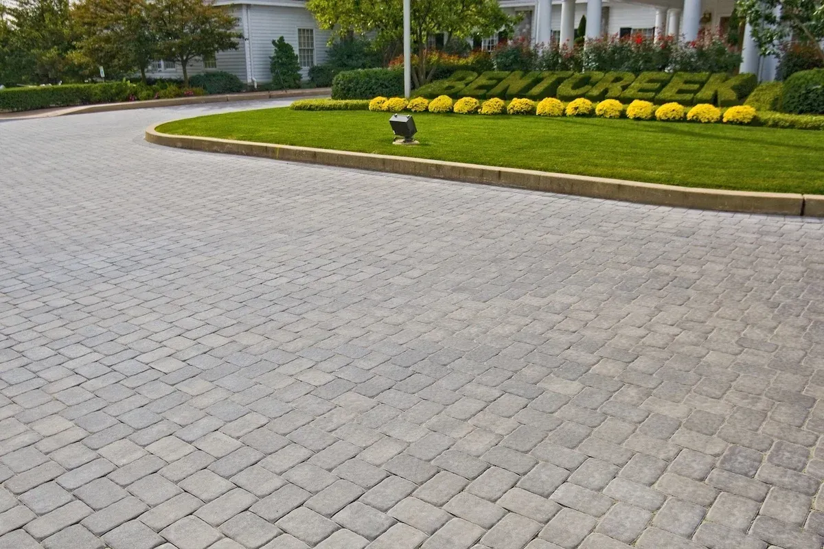 A brick driveway with a sign that says bent creek