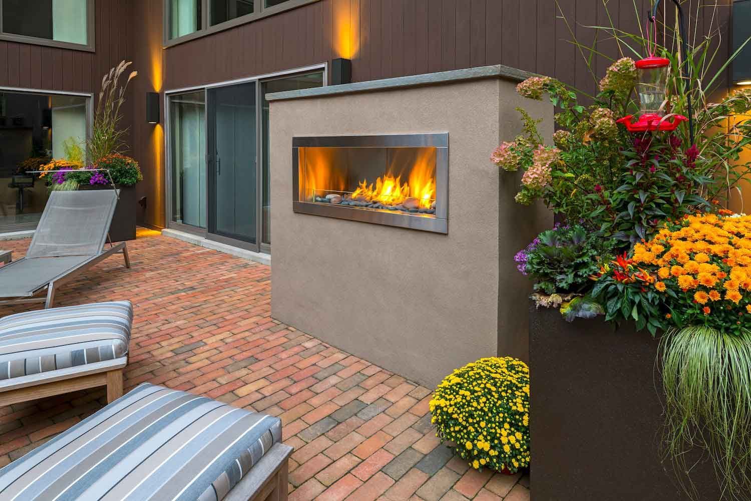 A brick wall with a lamp on top of it next to a garage door.