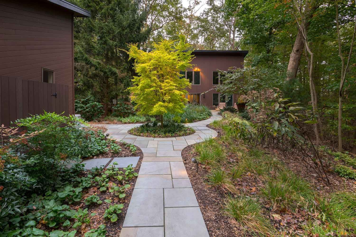 A stone walkway leading to a house in the woods