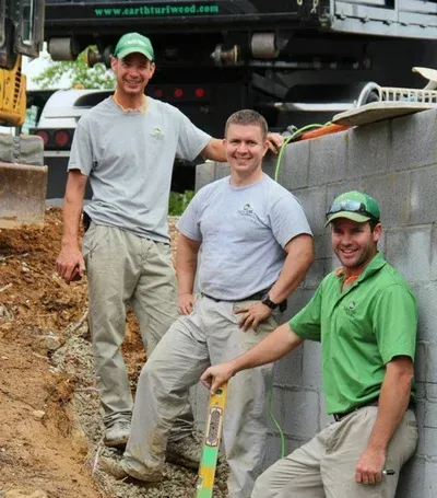 Three men are posing for a picture in front of a truck that says northstarweed.com