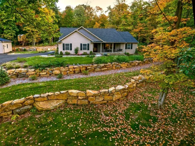 A house with a stone wall in front of it