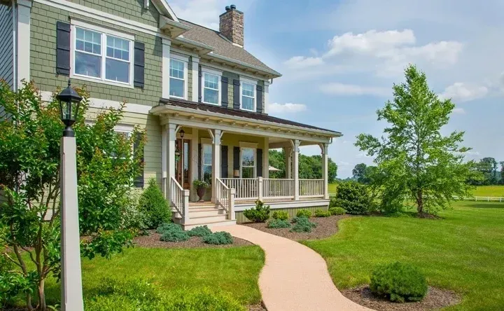 A large house with a porch and a walkway leading to it