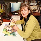A woman is sitting at a desk in front of a computer.
