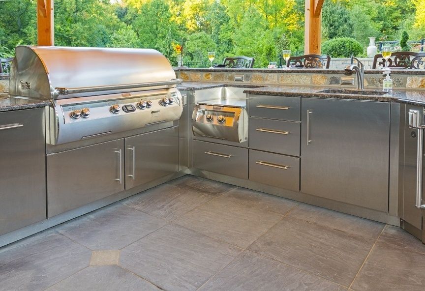 A kitchen with stainless steel cabinets and a grill.