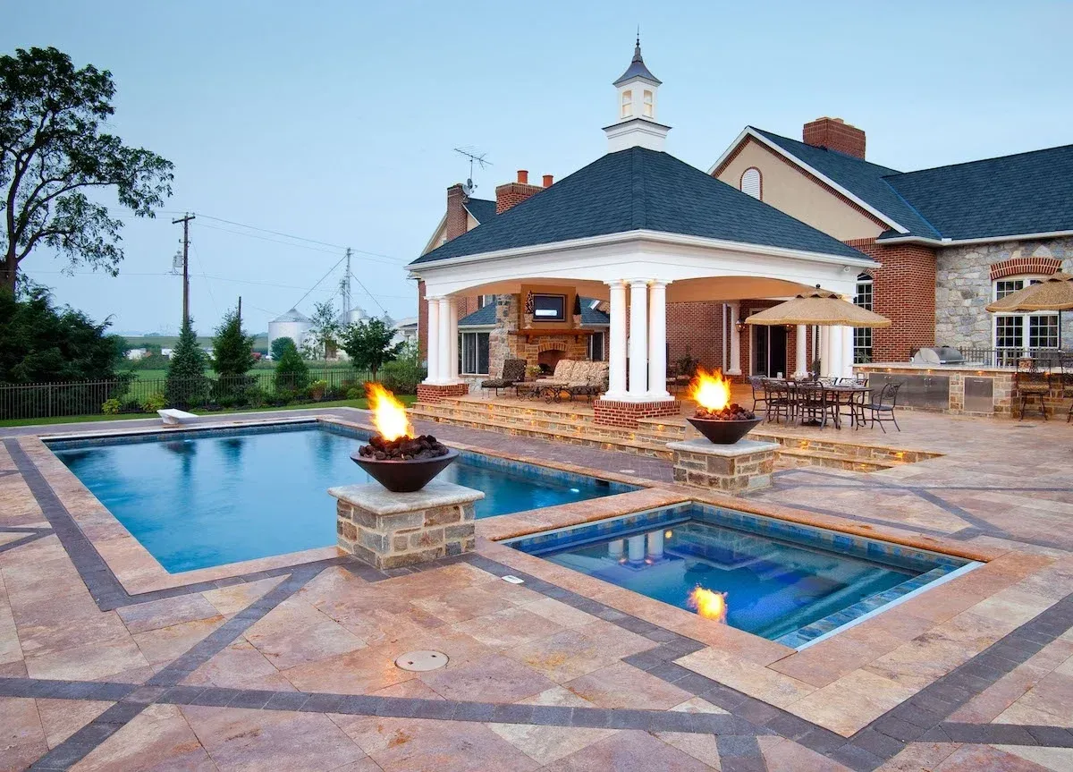 A large house with a swimming pool and a fire pit