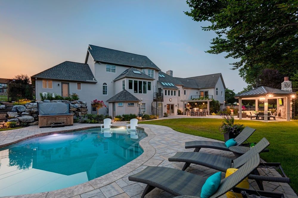 A large house with a large swimming pool in front of it.