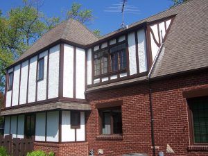 Brick-and-white Tudor-style house exterior with dormer windows and a sloped roof
