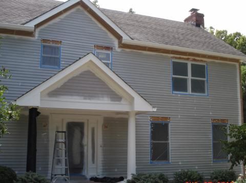 Gray two-story house with white trim and a small covered front porch