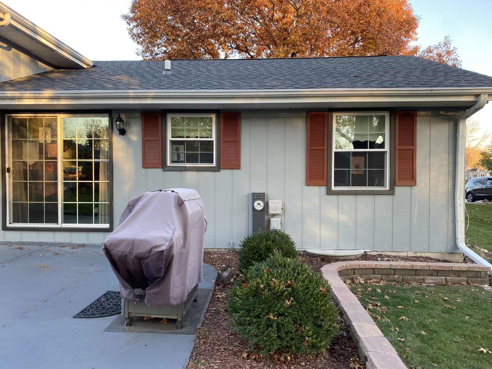 House exterior with covered grill, front window, and walkway in a small yard