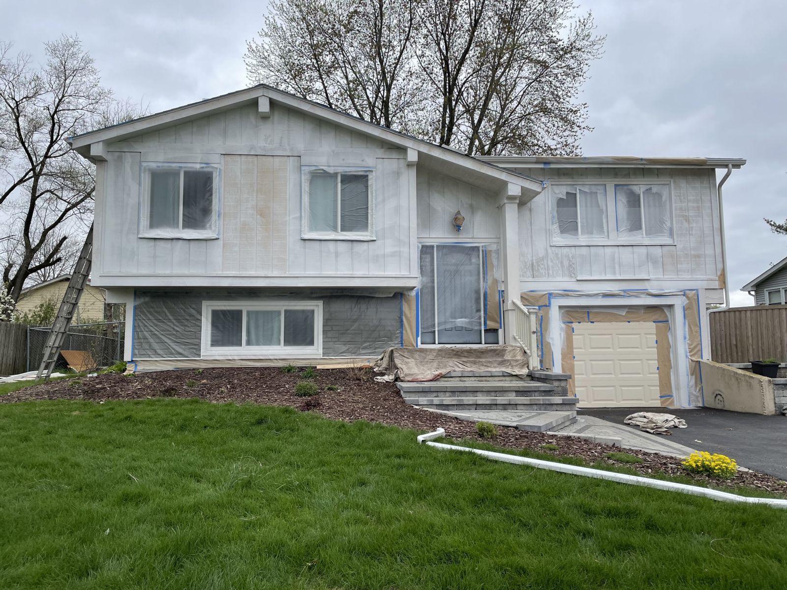 White split-level house with attached garage and front lawn on an overcast day
