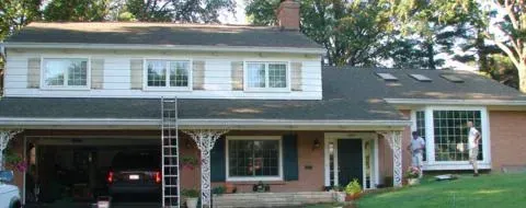 Two-story white house with a covered porch, garage, and front lawn