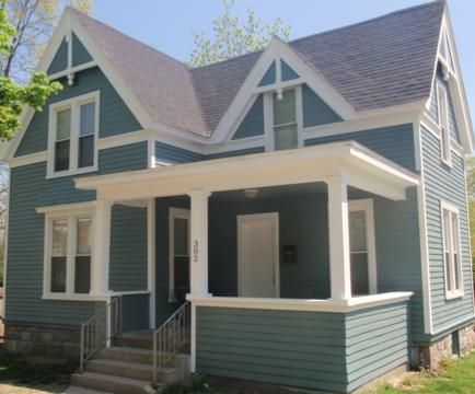 Blue Victorian-style house with white trim and front porch in daylight