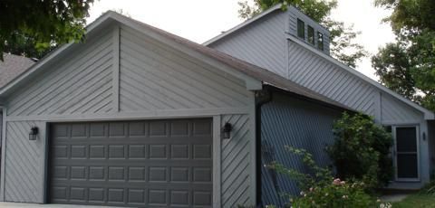 Gray house with attached garage and white trim, viewed from the front corner.