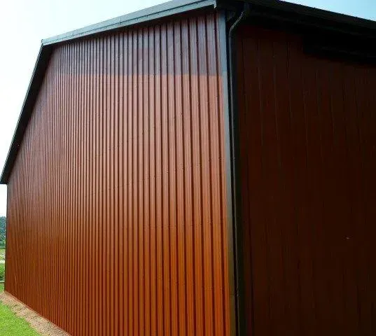 Brown wooden shed with vertical siding and a sloped roof, viewed from the corner outdoors