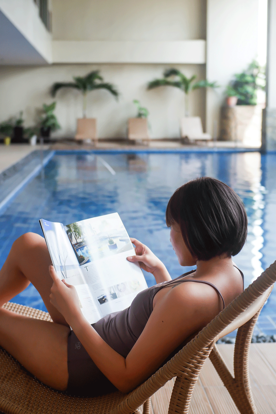 Guest enjoying a relaxing poolside read during her Makati staycation with pool access