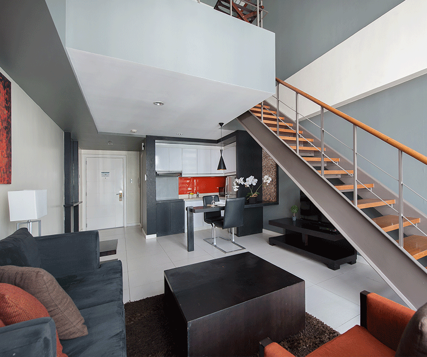 Modern loft living room with open kitchen and staircase at KL Serviced Resi