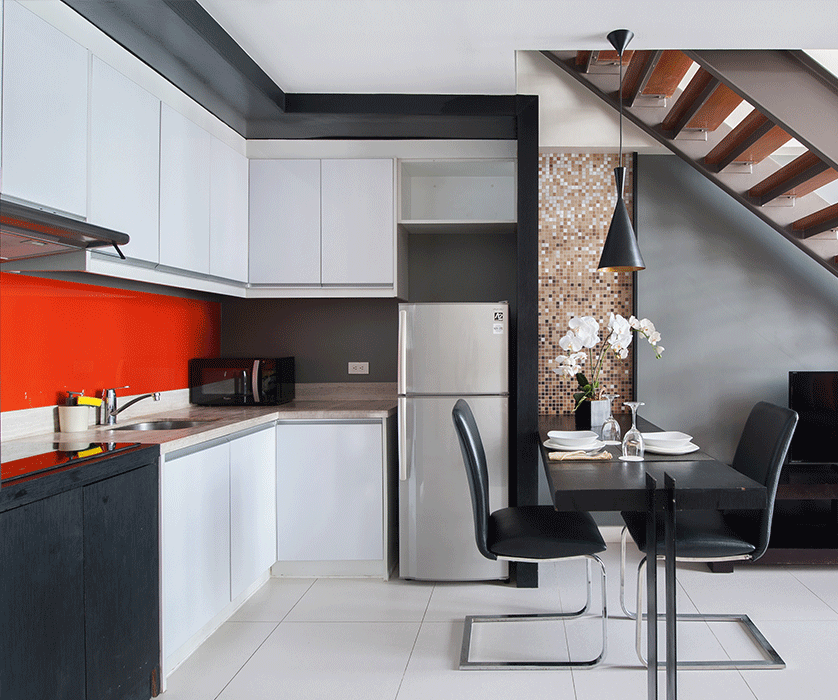 Modern kitchen with red backsplash and dining area at KL Serviced Residence