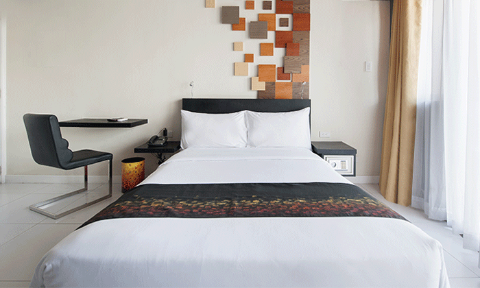 A hotel room with a bed , chair , desk and window KL Tower