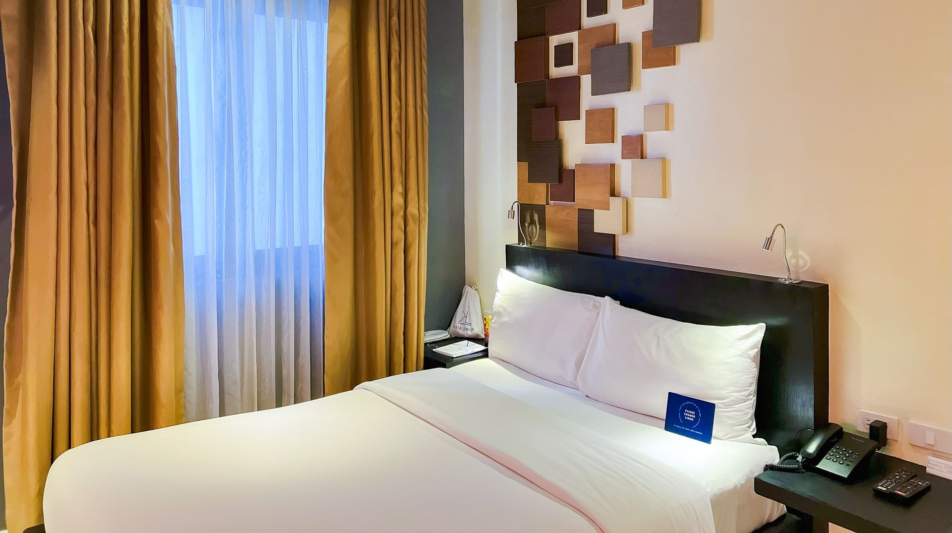 Modern hotel room near Greenbelt with stylish wall design and comfortable bed for a relaxing staycation in Makati.