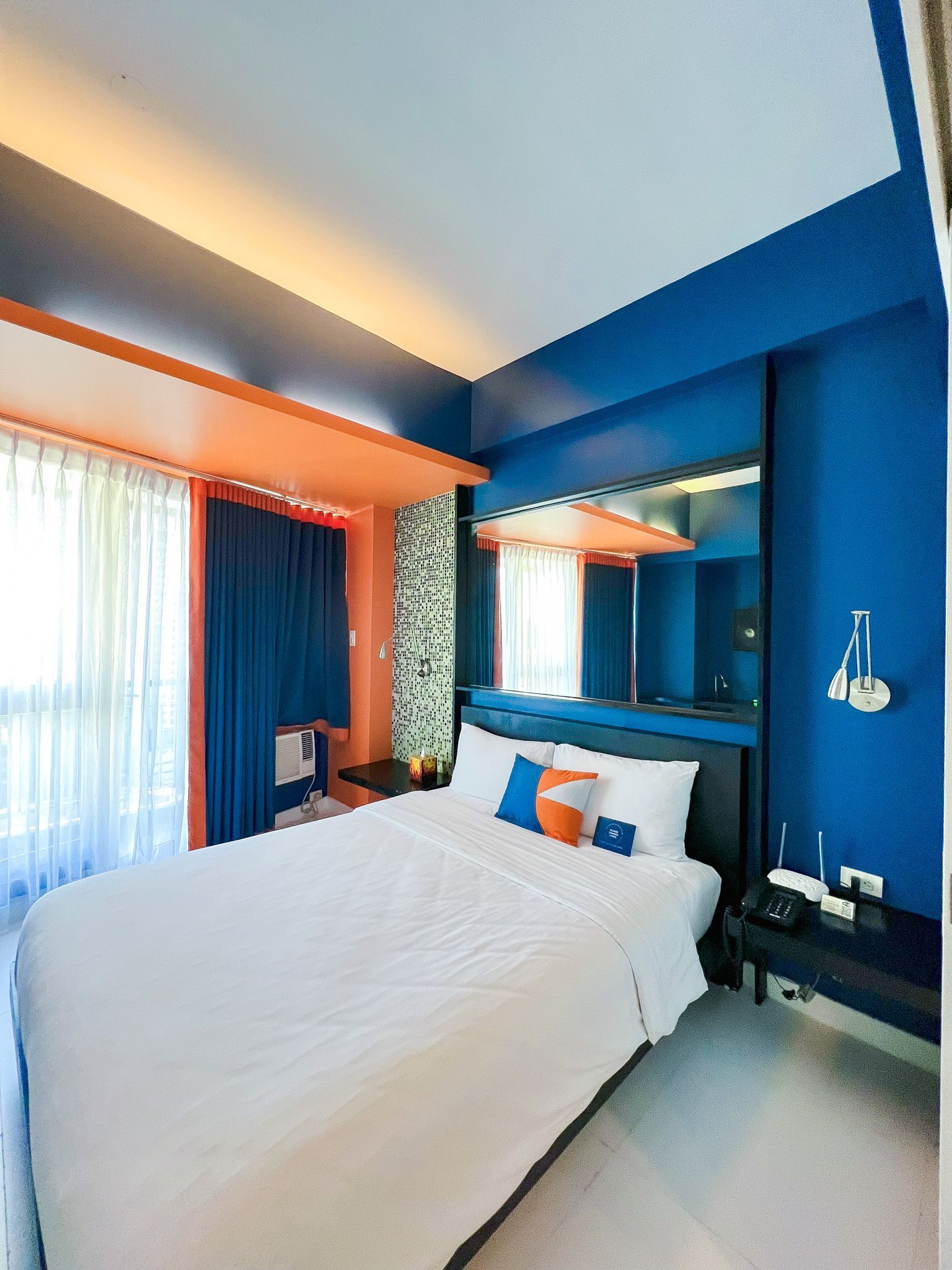 Comfortable hotel room with modern wooden headboard design, perfect for hotels near Greenbelt