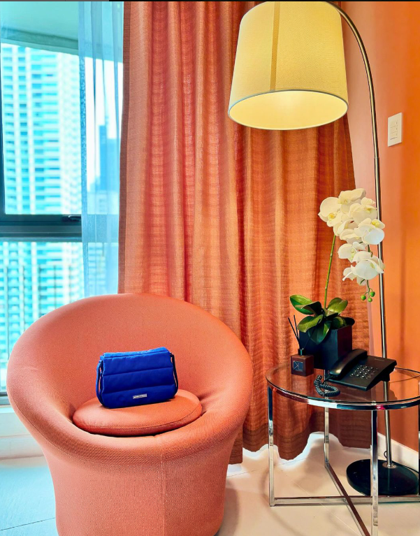 Blue handbag on coral accent chair in KL Serviced Residences Makati room