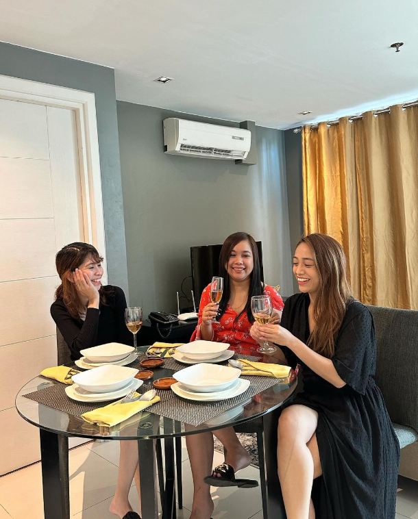 Three women enjoying wine at dining table in KL Serviced Residences Makati