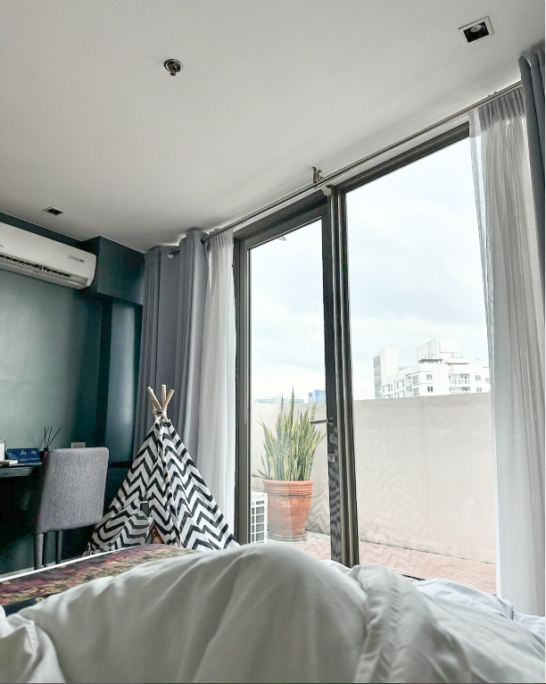 Bright hotel room with balcony access and teepee accent, providing a unique staycation experience.