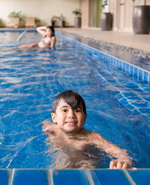 Child swimming in KL Serviced Residences indoor pool in Makati