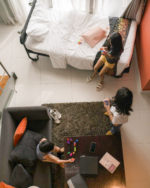 Family playing board games in a cozy KL Serviced Residences room