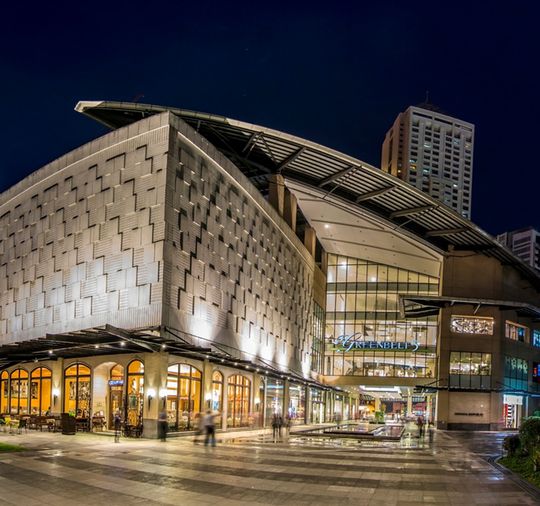 Contemporary building with illuminated glass architecture and geometric design at night